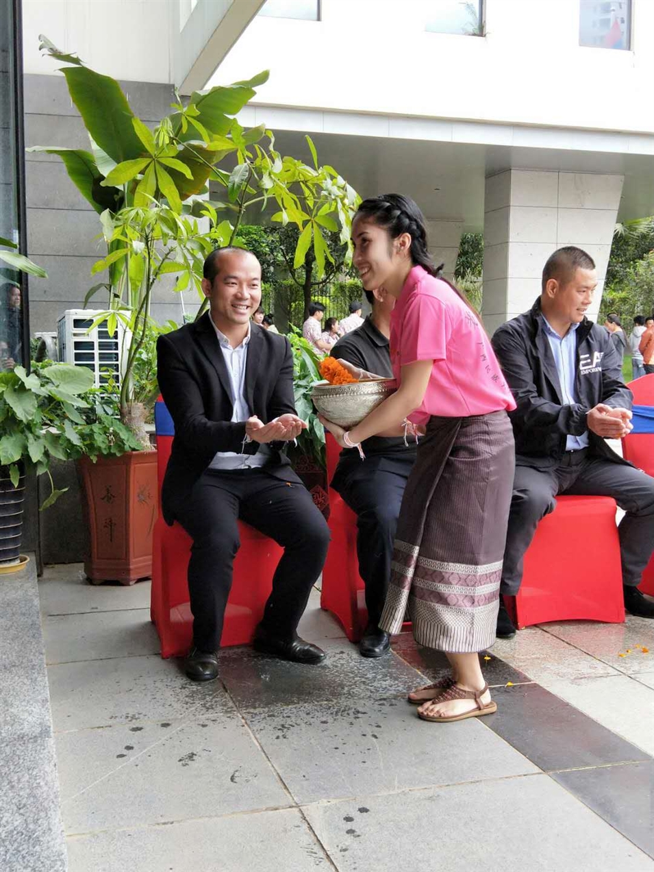 老撾駐廣西留學(xué)生代表將浸有花瓣的香水灑客人的手上，表示對(duì)嘉賓的美好祝福（圖一）